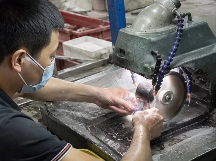 CuiShen craftsperson cutting gemstone material at a wet saw